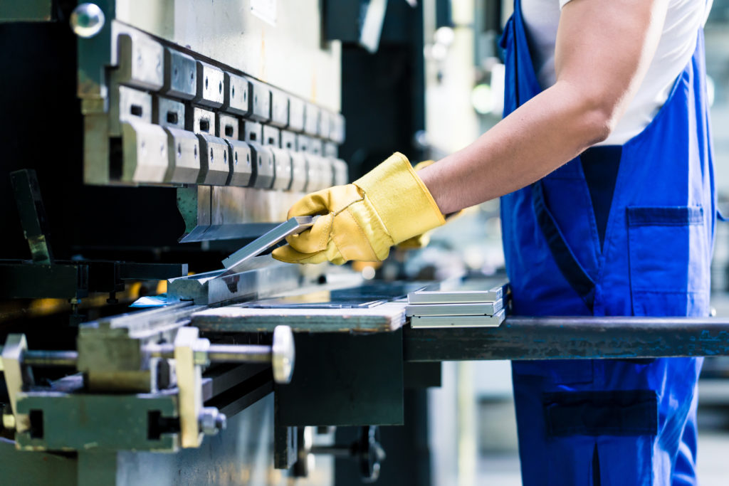 man operating a metal bending machine