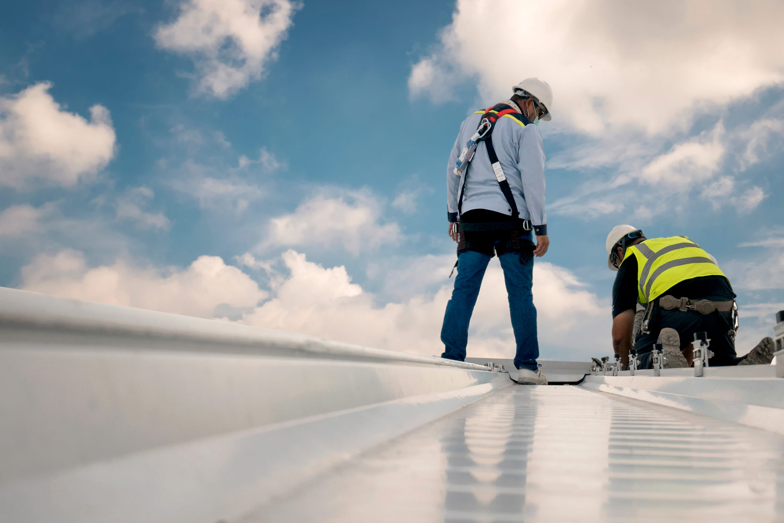 Roofers working on a metal roof Roofers working on a metal roof
